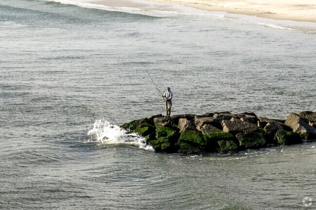 Locals fish along the shores of East Atlantic Beach at dusk.