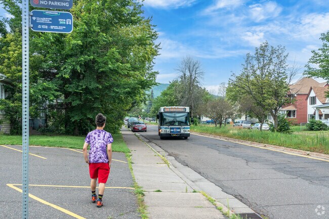 A man awaits the bus at a stop in the Cody neighborhood.