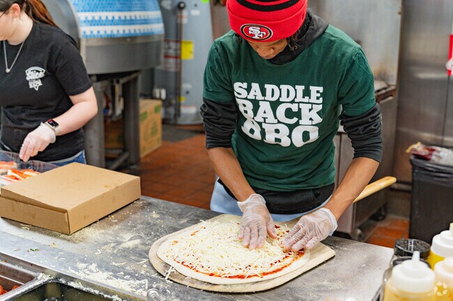 An employee makes a pizza at Slice by Saddleback-South Lansing in Old Everett.