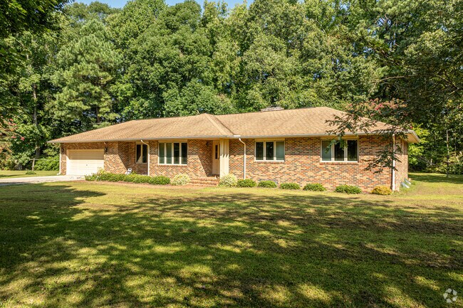 This ranch home is partially secluded by trees and sports a front-facing garage.