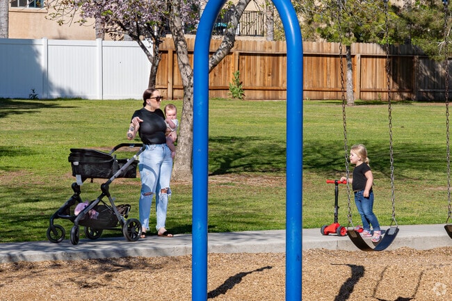 Residents enjoy walking the North Meadows Park paved paths with their children.