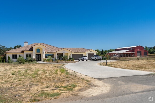A large Spanish style inspired home sits adjacent to a barn style home in Garden Farms.