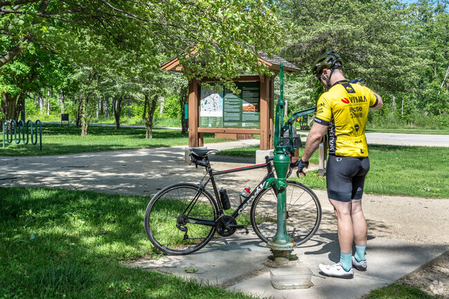 A cyclist works the water pump at Captain Daniel Wright Woods near Mettawa.