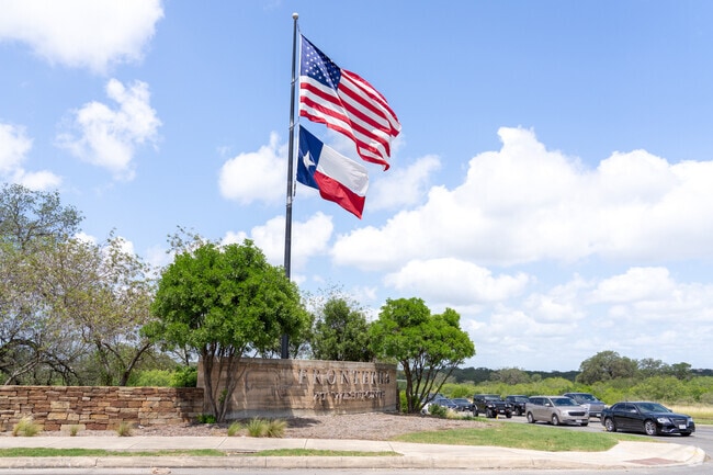 At the entrance of Fronterra at Westpointe, the Texas and American flags stand tall, symbolizing pride and unity in this master-planned community.