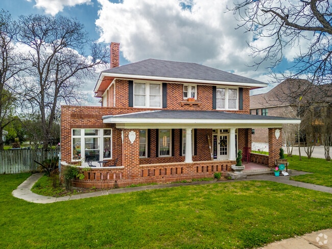 The brick home with a large front porch is in Floresville, TX.