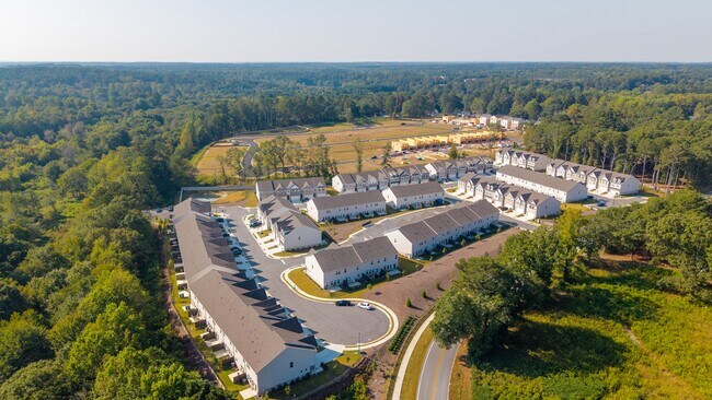 Community aerial showcasing homes, streets, and green spaces from above.