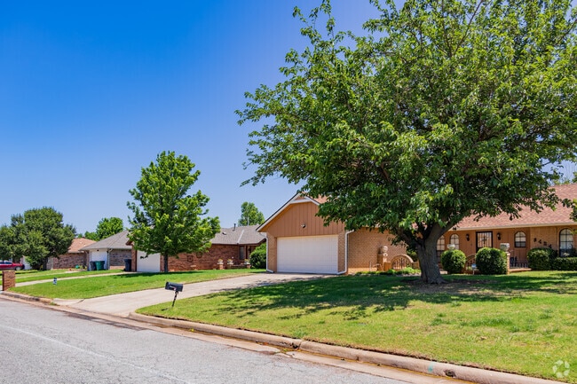 A row of brick traditional homes lined with trees in the Springfield neighborhood.