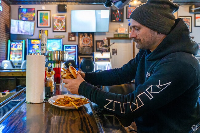 A Salem Lake resident enjoys a specialty burger and fries at Uncle George's Bar & Grill.