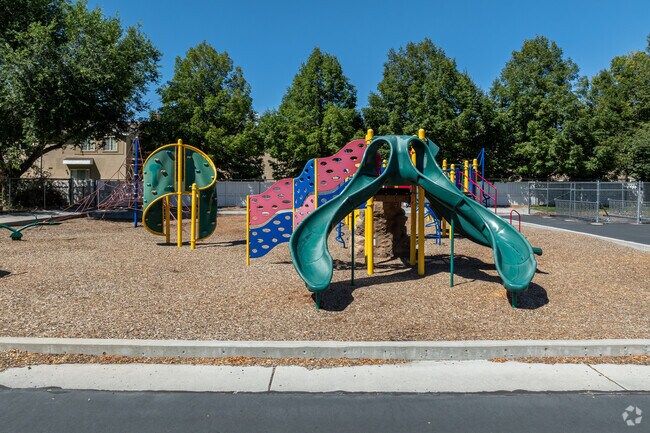Mature trees line the perimeter of the play area at Heartland Elementary School.