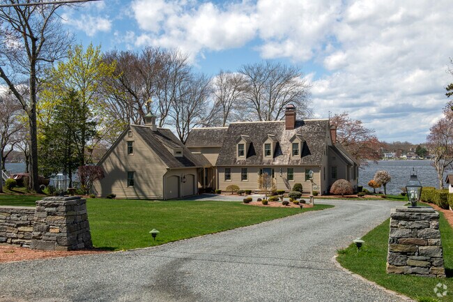 Lanterns on a stone fence grace the entry to this waterfront property in North Westport.