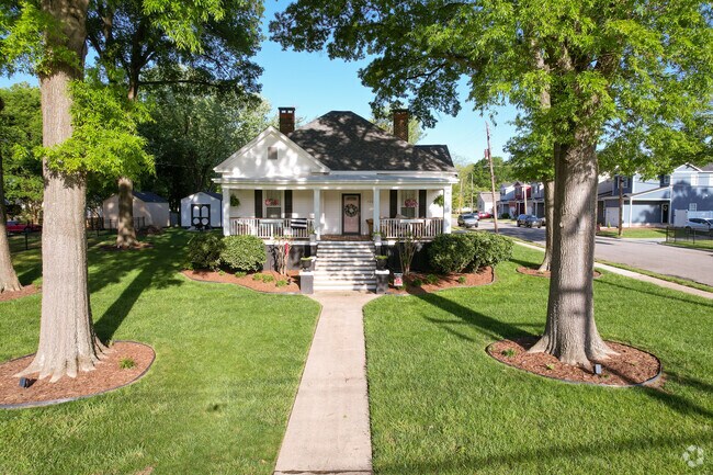 A cottage style home with manicured landscaping in Car Town.