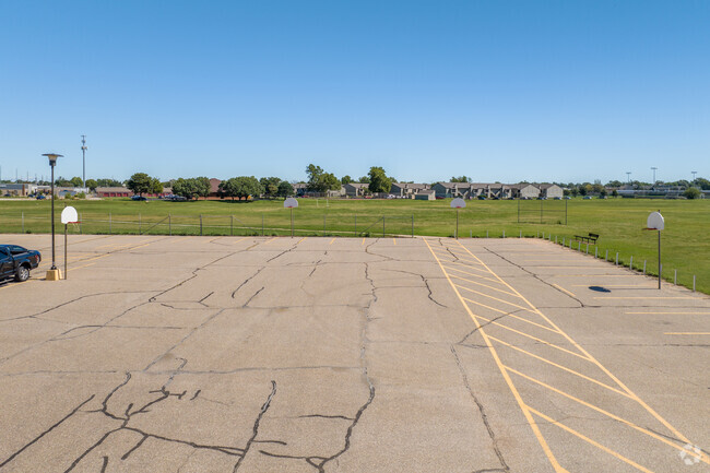There are several basketball goals in the parking lot of Wilbur Middle School.