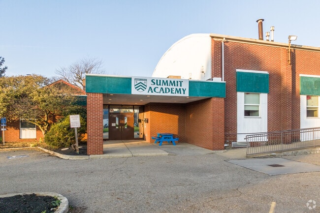 Summit Academy is in a single story brick building with rounded roof.