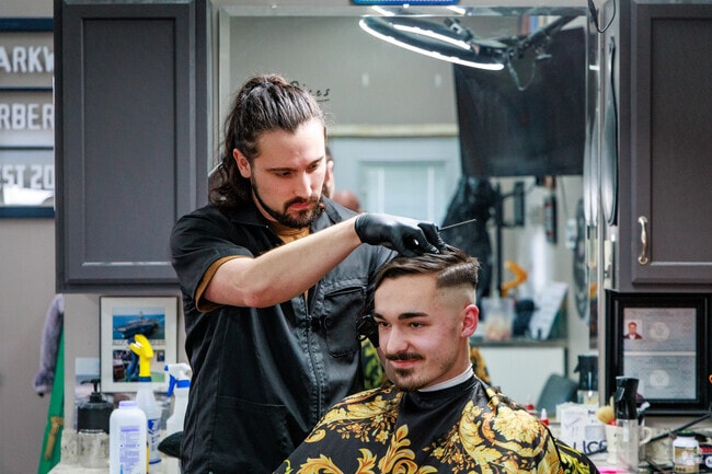 A man gets a trim by the master barber Parker at Parkway Barber Shop in Oneida.