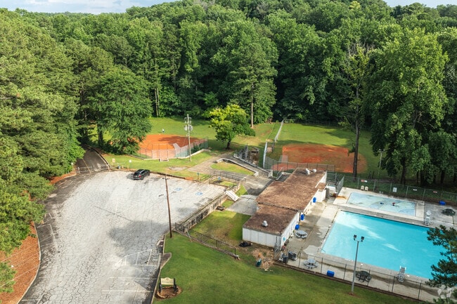 Kittredge Park includes baseball fields and a seasonal pool under pine trees.