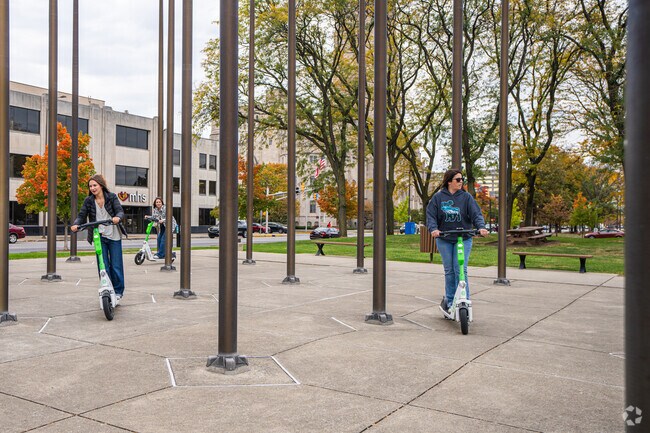 Visitors can travel the sprawling green spaces of  University Park on scooters.