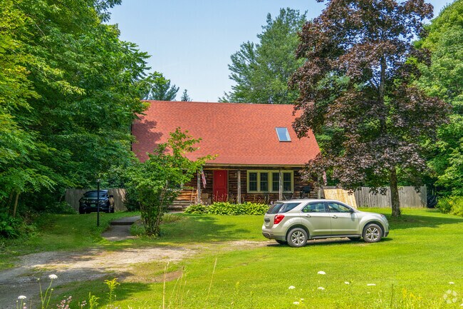 Log cabin-style architecture adds rustic charm to this wooded Huntington property.