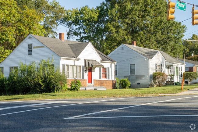 A pair of cape-cod style houses with very small front lawns.