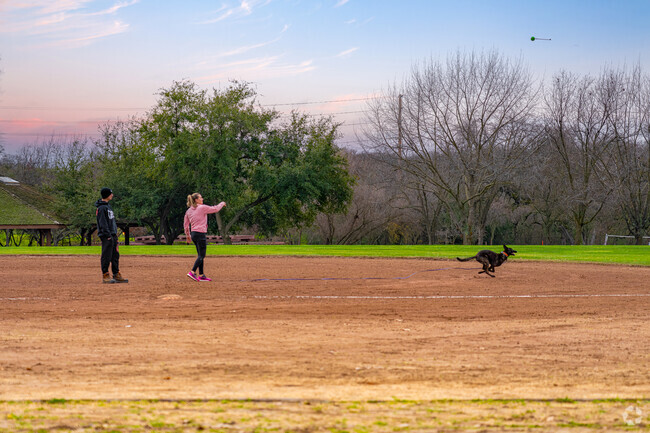 Woman lets dog run at Blue Oaks Park in Campus Oaks.