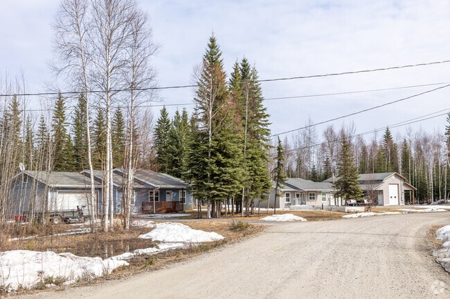Rustic cabin-style homes line a gravel road in the Badger neighborhood of Fairbanks.