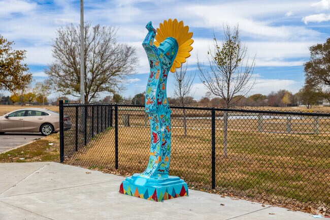A mini Keeper of the Plaines statue stands in front of the dog park at Harrison Park.