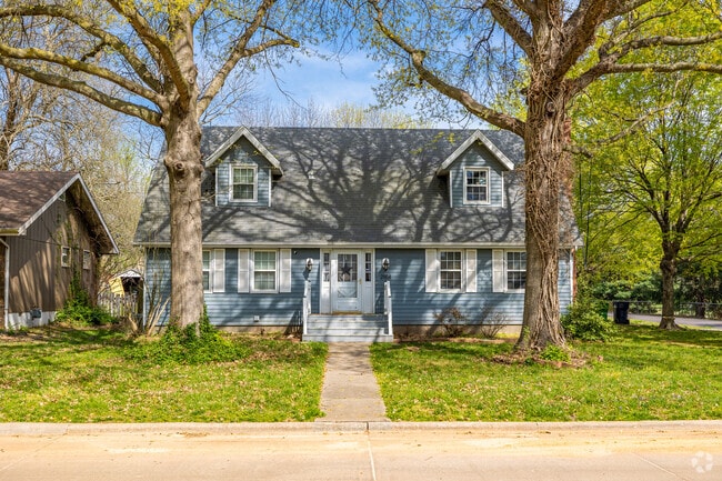 This large colonial revival home is framed by two large shade Trees in the Sherwood neighborhood