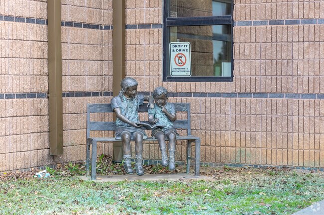 The statue of two children reading a book together sits outside Larkin Bailey Elementary School.