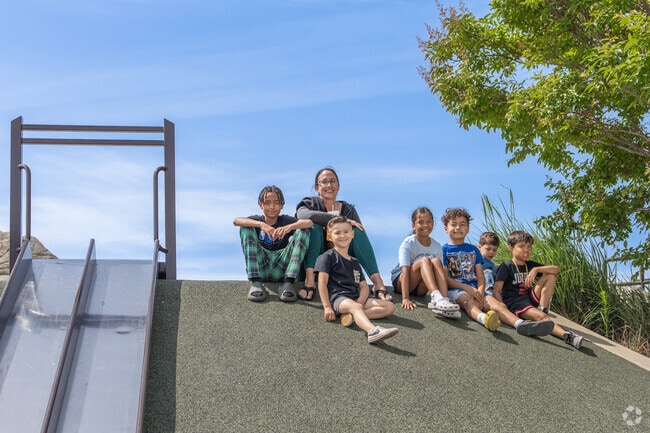 A group sits atop a play-hill at Hayward Recreational Park.