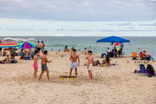 Beach goers enjoying the day with friends and outdoor sports in Miami Beach.