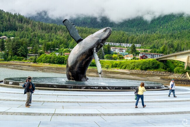 A life-sized whale sculpture emerging from an infinity pool is situated near West Juneau.