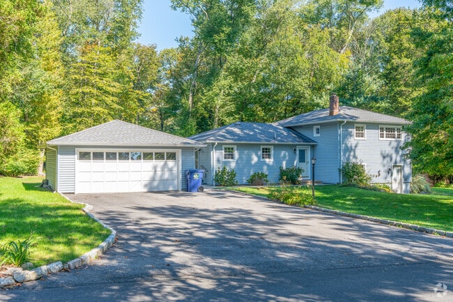 Single-story home in Cranbury with a serene blend of blue-gray siding and natural surroundings.