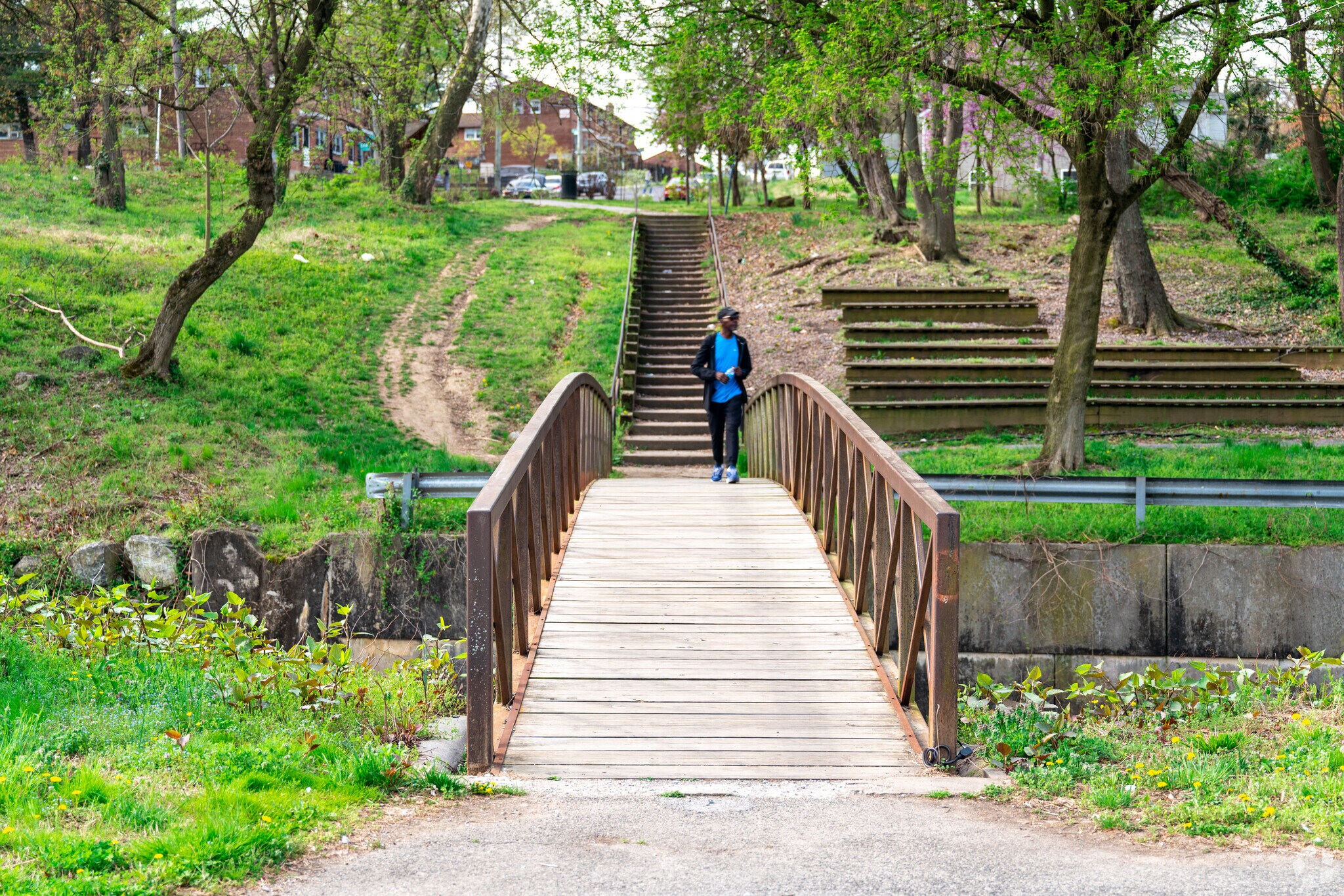A rustic wooden bridge spans the Watts Branch Creek running through Marvin Gaye Park