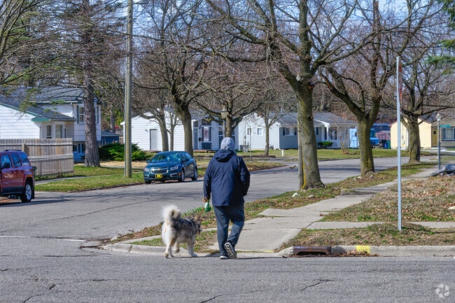A man walks his dog along single-family homes in Churchill Downs.