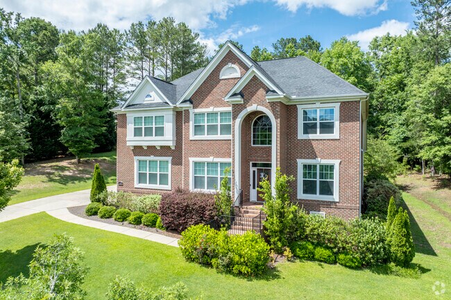 Clean lines and shapes of this French Colonial design stand out among the trees' organic shapes.