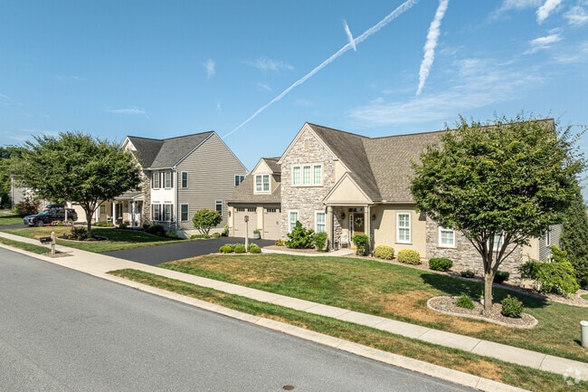 A newer, contemporary build is set next to a colonial-style neighbor in Oyster Point.