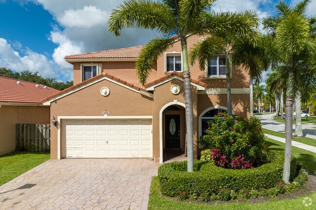 Mediterranean Revival single-family homes have lush palms and greenery.