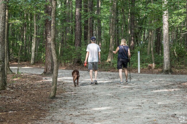 Couple walking their dog on the trail at Huguenot Park.