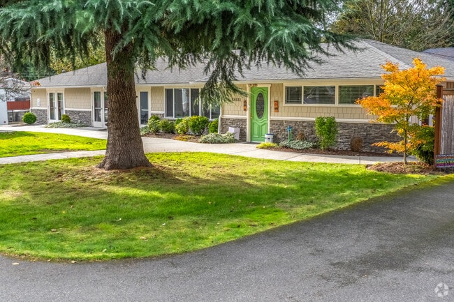 This ranch home in Uplake features an evergreen tree in its spacious front yard.