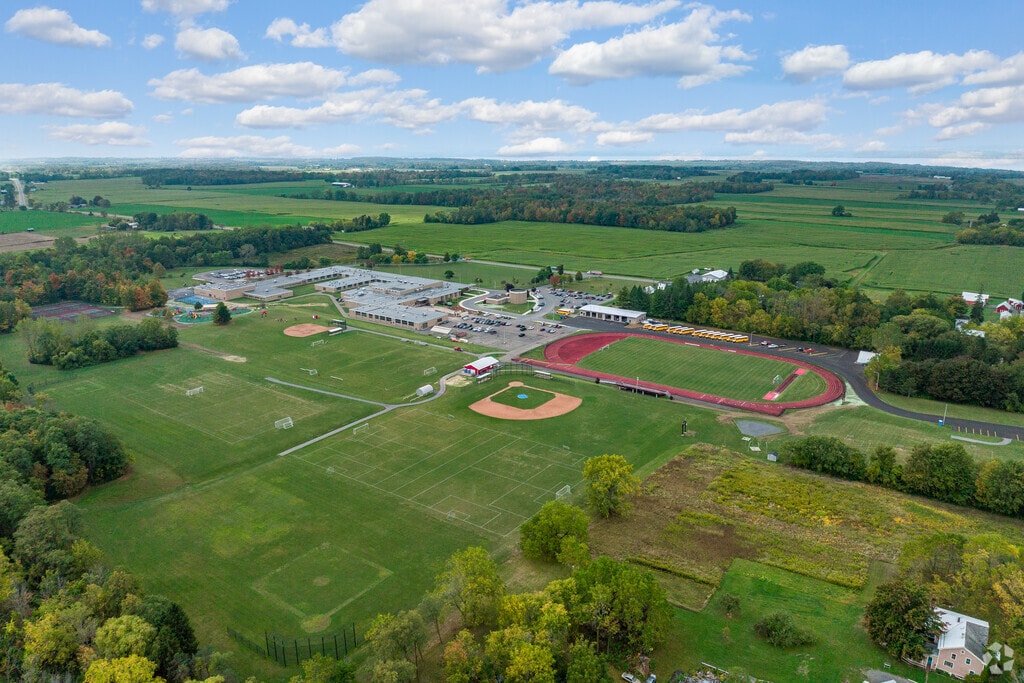 Southern Cayuga High School is in a rural setting surrounded by rolling green fields and trees.