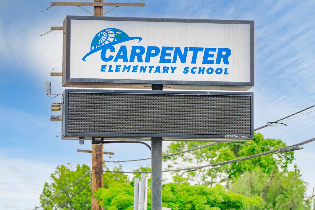 A large sign displays Carpenter Elementary School in Downey, California.