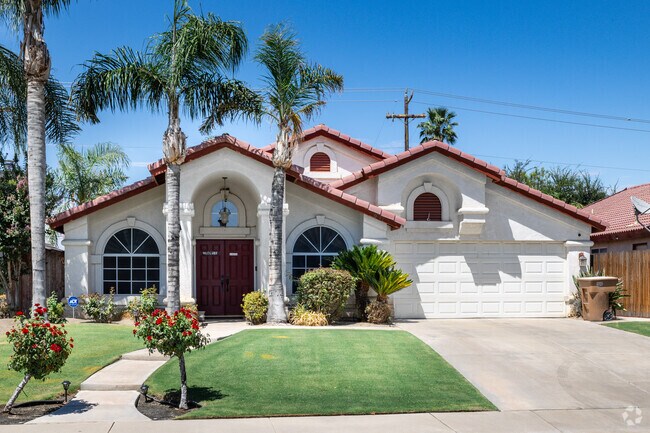 This Spanish-style home in Fairway Oaks features large palms in the front yard.