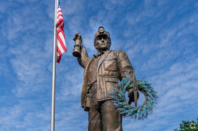 A Miner statue marking the entrance to Forestville and Minersville represents coal mining history.