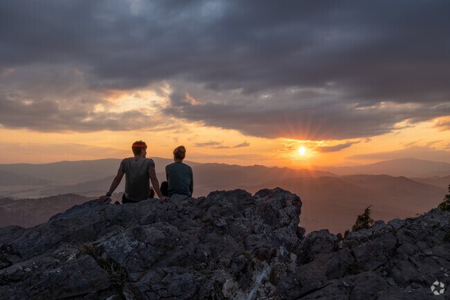A couple rests to watch the last rays of light touch the peak of Mount Helena.