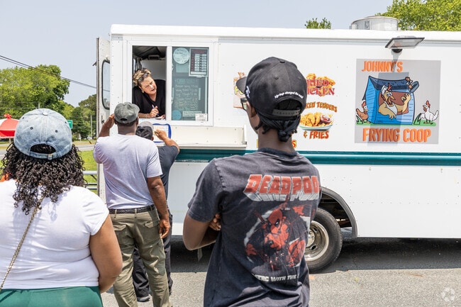 A long line forms at Johnny’s Frying Coop food truck in Temperanceville, known for crispy chicken and a devoted following.