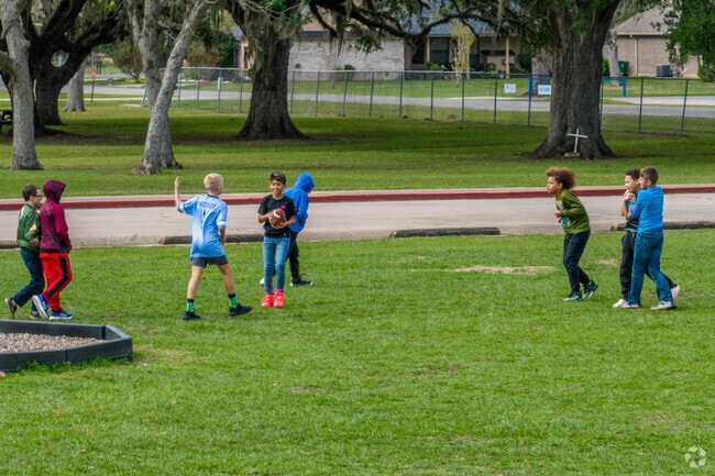 Children play football on one of the many green spaces in Sweeny, Texas.