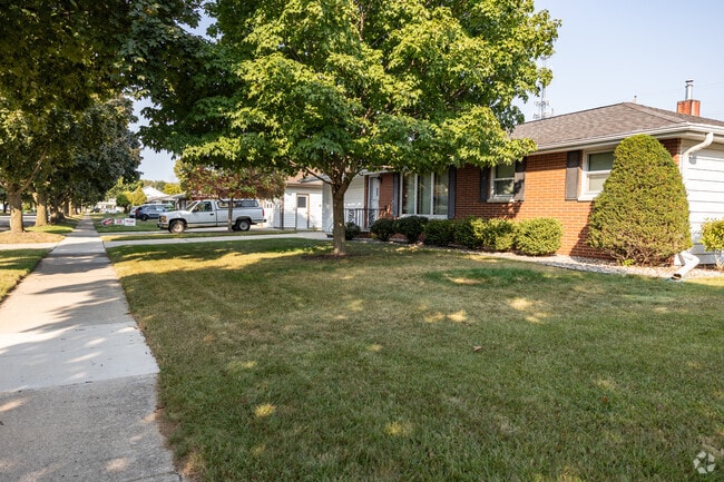 Residential streets include paved sidewalks and a variety of trees.