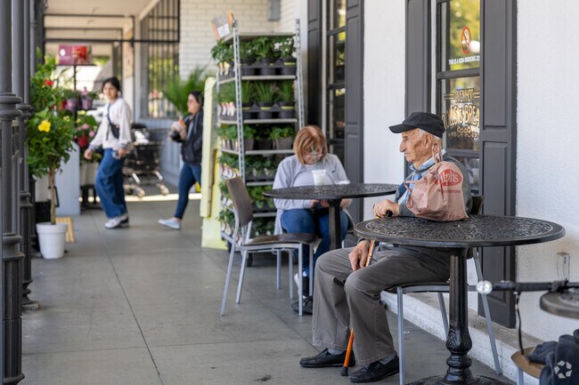 Individuals unwind on the benches outside Ralphs Fresh Fare, people-watching and enjoying the bustling atmosphere of the surrounding Brockmont neighborhood.