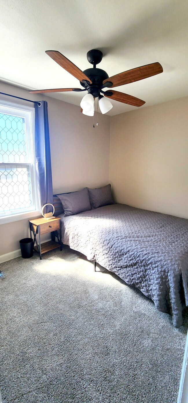 Secondary bedroom featuring a Queen bed, blackout curtains, wireless phone charger and sound machine