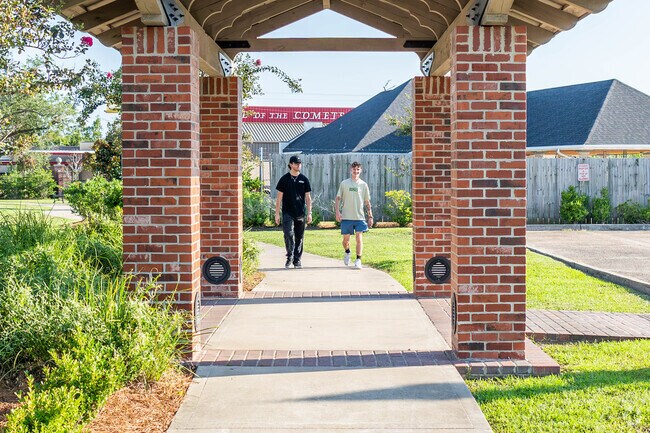 Friends take a leisurely stroll along the paved sidewalk at Center Circle Park in Beverly Hills.
