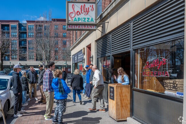 Locals line up outside of Sally's Apizza near Dwight as soon as it opens.